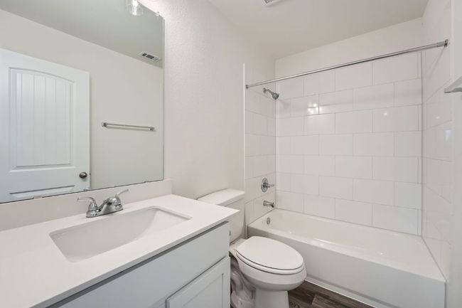 Full bathroom with visible vents, toilet, bathing tub / shower combination, wood finished floors, and vanity | Image 23