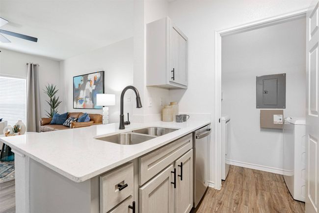 Kitchen featuring kitchen peninsula, sink, light hardwood / wood-style flooring, dishwasher, and electric panel | Image 30