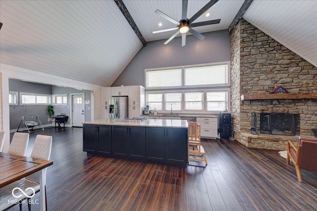 kitchen with an open floor plan that includes a sitting area and a wood burning fireplace | Image 28