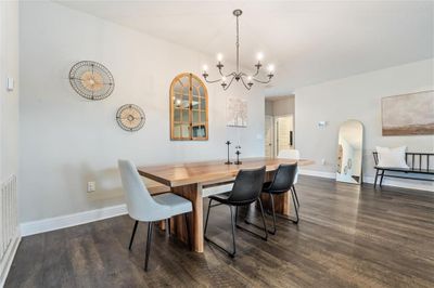 Dining area with a chandelier and dark wood-type flooring | Image 3