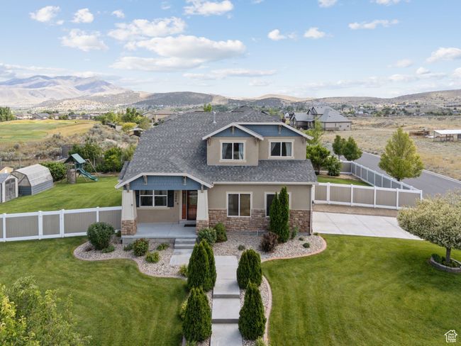 View of front of house with stone siding, a mountain view, a shingled roof, stucco siding, and a porch | Image 53
