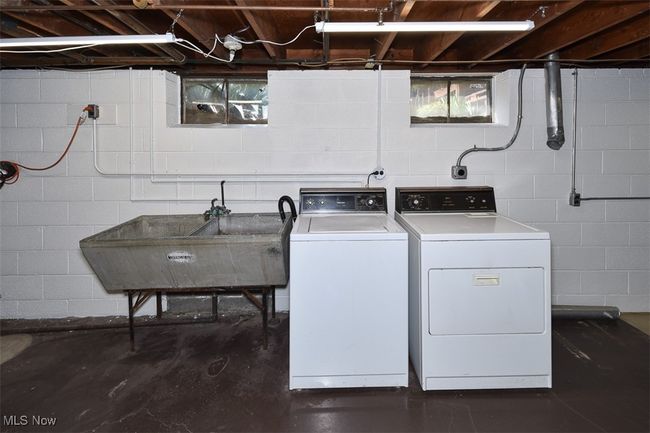 Washroom with washer and clothes dryer, a sink, and laundry area | Image 41