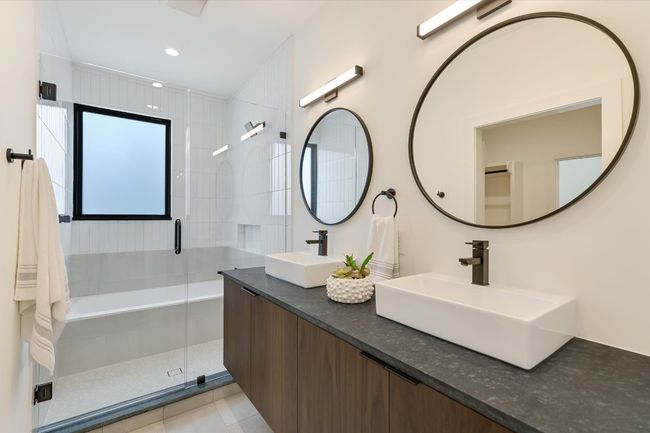 Bathroom featuring a stall shower, double vanity, tile patterned floors, and recessed lighting | Image 19