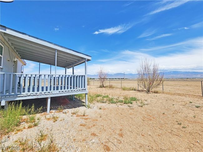 View of yard featuring fence, a rural view, and a deck with mountain view | Image 30