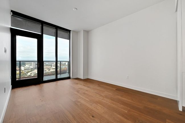 Spare room featuring baseboards, expansive windows, and wood finished floors | Image 15