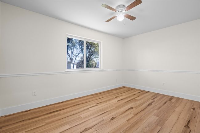 Spare room featuring wood finished floors, baseboards, and a ceiling fan | Image 16