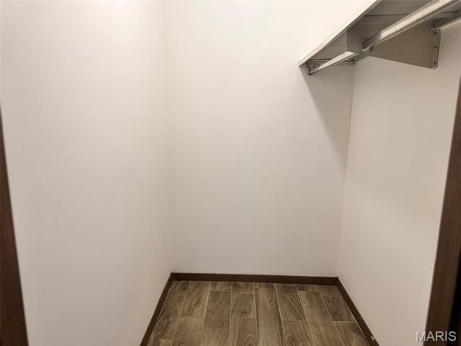 Walk in closet with dark wood-style flooring | Image 7