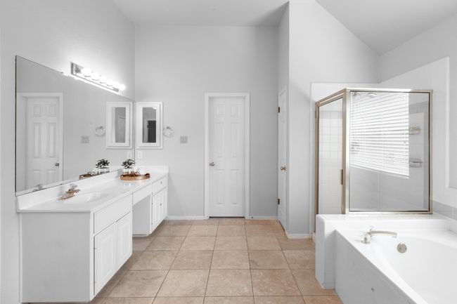 Full bathroom with double vanity, a bath, a stall shower, high vaulted ceiling, and tile patterned floors | Image 27