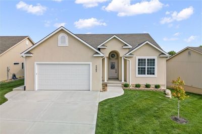 Ranch-style house with a garage and a front lawn | Image 1