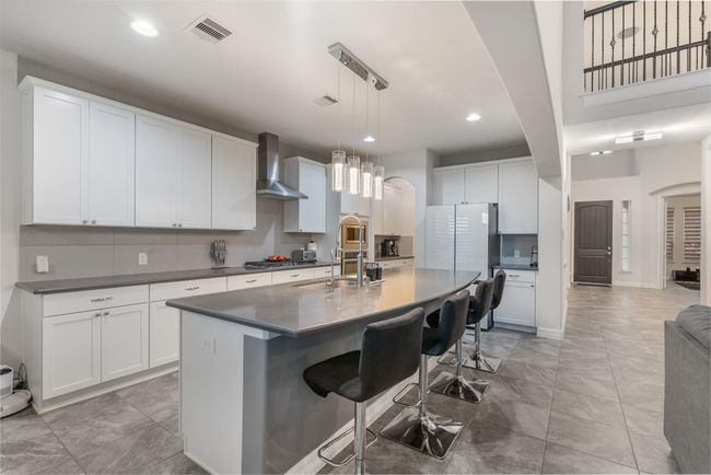 This modern kitchen seamlessly connects with the living area, offering a perfect space for entertaining | Image 14