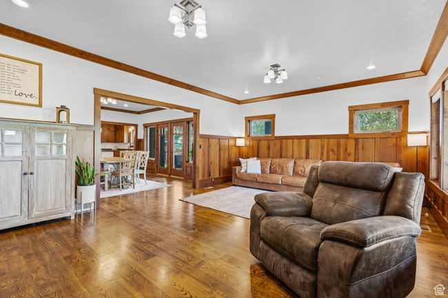 Living room with hardwood / wood-style flooring, ornamental molding, an inviting chandelier, and french doors | Image 8