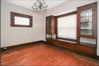 Empty room featuring hardwood / wood-style floors and an inviting chandelier | Image 2