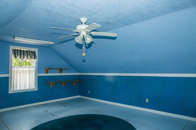 Additional living space featuring lofted ceiling, a ceiling fan, and a textured ceiling | Image 21
