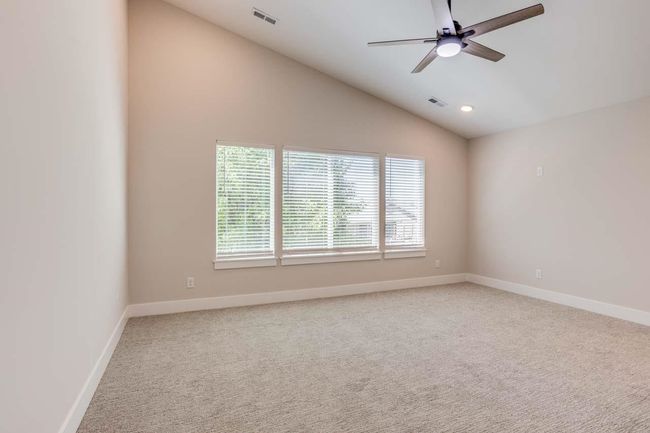Carpeted spare room featuring ceiling fan, baseboards, lofted ceiling, and recessed lighting | Image 19