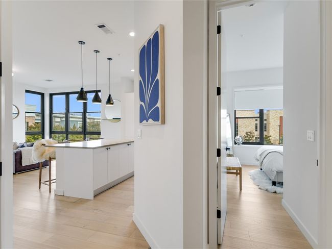 Corridor with visible vents, plenty of natural light, baseboards, and light wood finished floors | Image 4