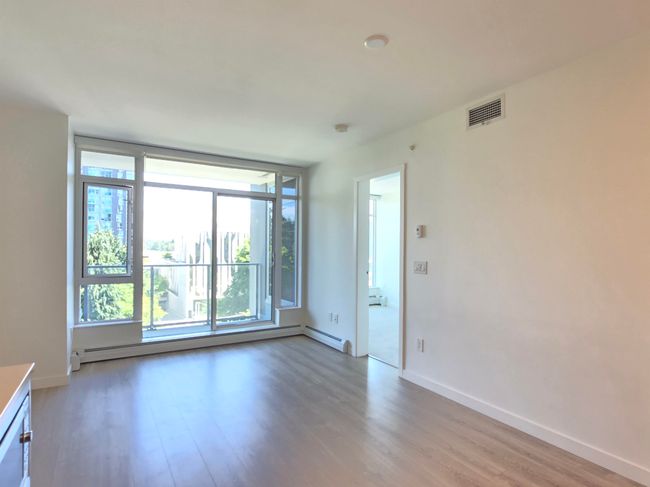 Empty room with light wood-type flooring and a baseboard radiator | Image 7