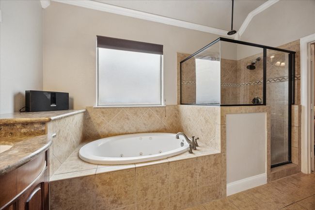 Full bathroom with a tub with jets, a shower stall, vanity, tile patterned floors, and crown molding | Image 14