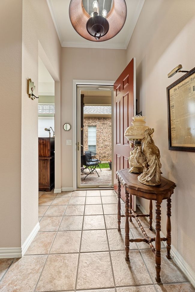 Doorway with crown molding, baseboards, and light tile patterned flooring | Image 34