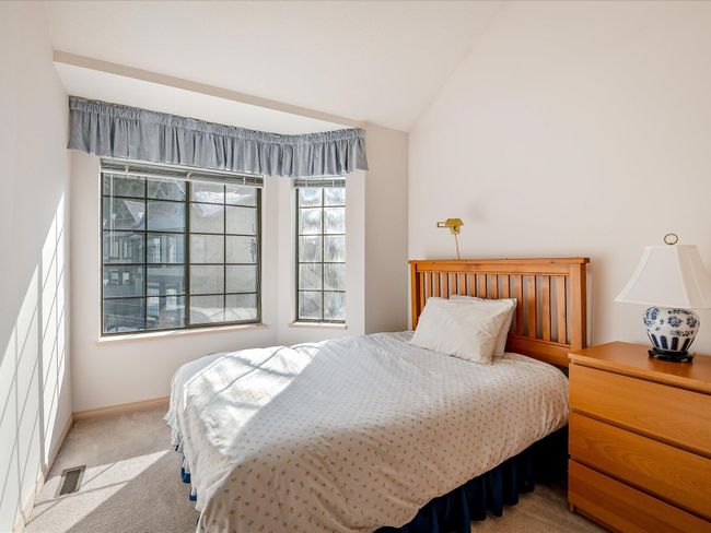 Carpeted bedroom with vaulted ceiling, visible vents, and baseboards | Image 19