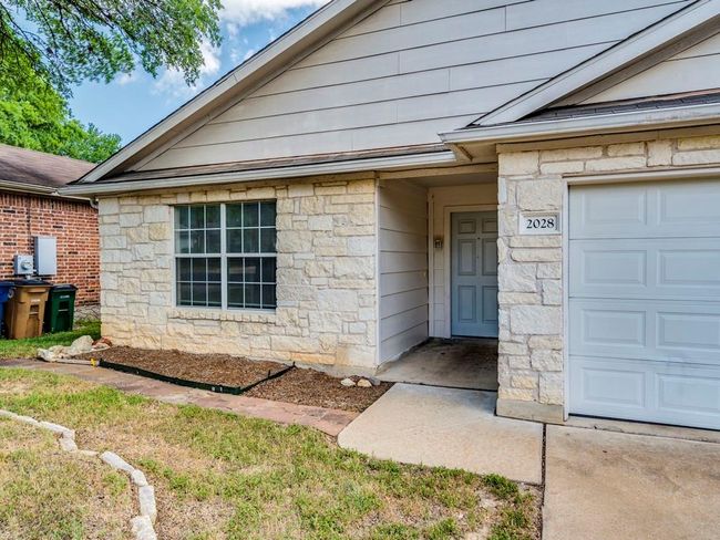 Property entrance with stone siding and an attached garage | Image 6