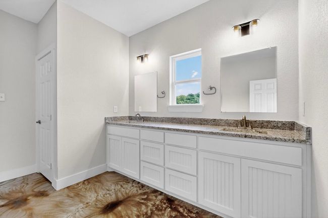 Bathroom with double vanity and baseboards | Image 29