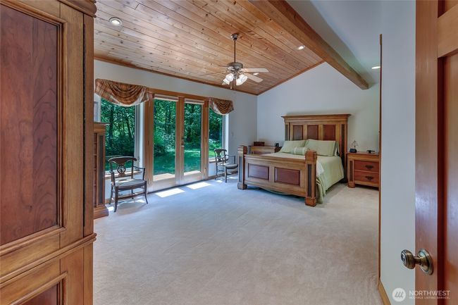 Primary retreat located on the main level. Wood clad ceiling adds to the rustic appeal. New carpet. | Image 11