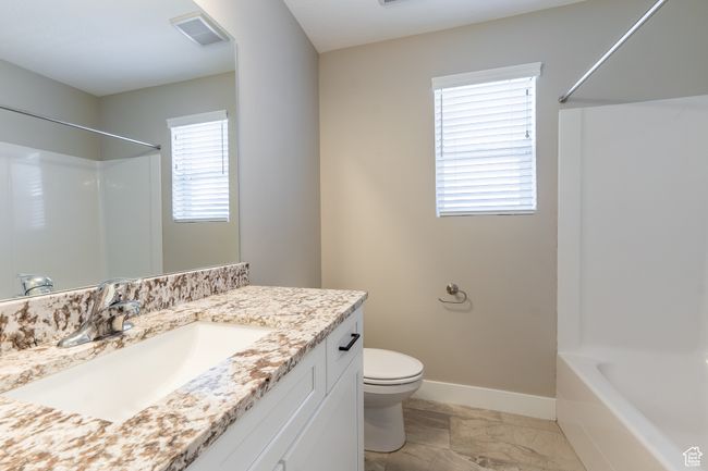 Bathroom with marble finish floors, vanity, and tub / shower combination | Image 8
