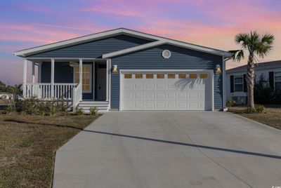 View of front facade featuring a porch and a garage | Image 1