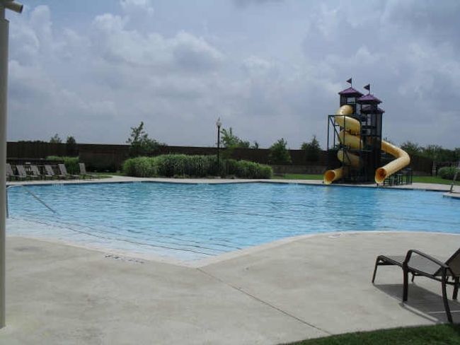 Community pool with a water slide and a patio | Image 22
