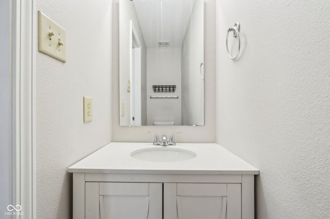 bathroom featuring vanity, toilet, and a textured wall | Image 47