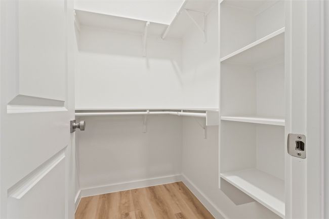 A stylish, spacious primary closet with ample storage and sleek shelving—captured from a fresh angle to showcase its modern design and organization. | Image 20
