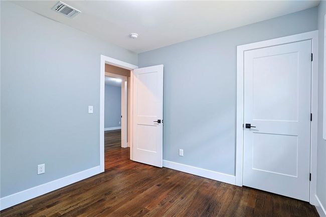 Unfurnished bedroom featuring dark wood-type flooring | Image 17