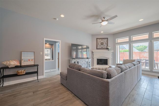 The spacious living area features a stunning cast stone fireplace, creating a warm and lovely focal point for relaxing or entertaining. | Image 13