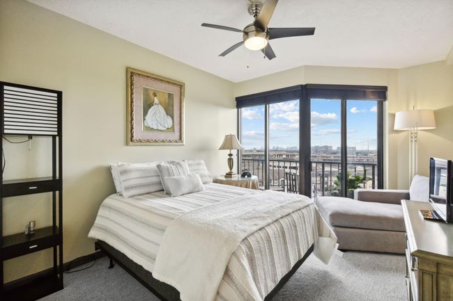 Bright and airy bedroom with a large window that offers an expansive view, bringing in plenty of natural light. | Image 19