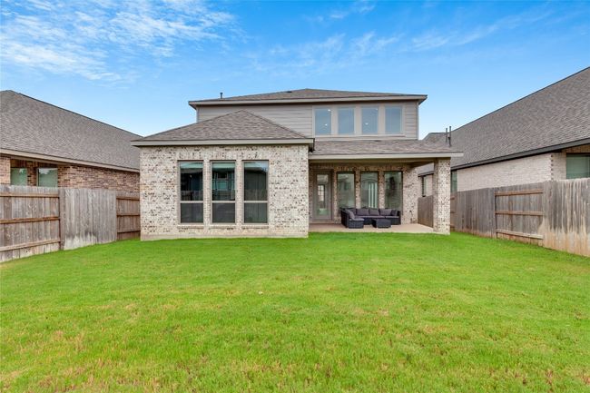 Back of property featuring outdoor lounge area, a fenced backyard, brick siding, and a shingled roof | Image 39