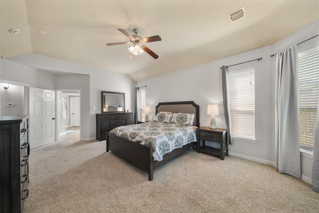 A view of the owner's bedroom with access to the private bath shown in the background. | Image 23