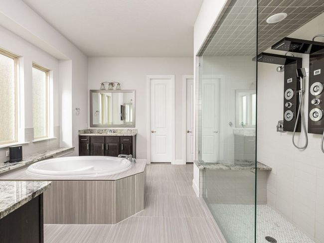 Bathroom featuring vanity, a garden tub, and a tile shower | Image 15