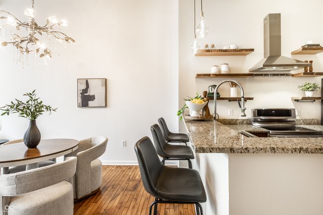 kitchen with island exhaust hood, electric range, open shelves, hardwood / wood-style flooring, and light stone countertops | Image 13