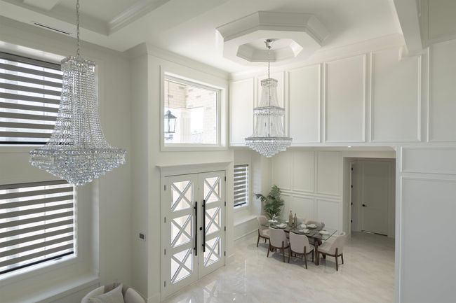 Foyer entrance featuring a chandelier, a decorative wall, healthy amount of natural light, a raised ceiling, and ornamental molding | Image 18