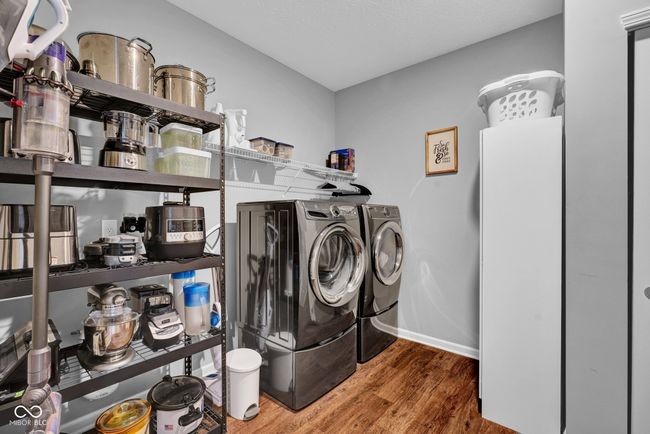 washroom featuring laundry area, independent washer and dryer, wood finished floors, and baseboards | Image 10