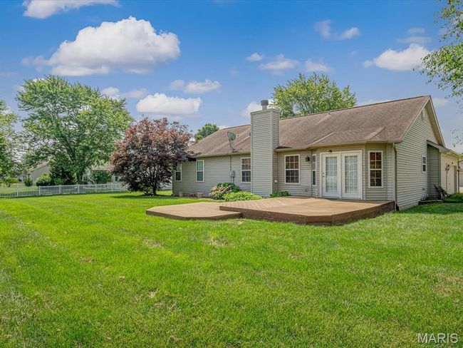 Back of house featuring a chimney, a deck, a patio | Image 32