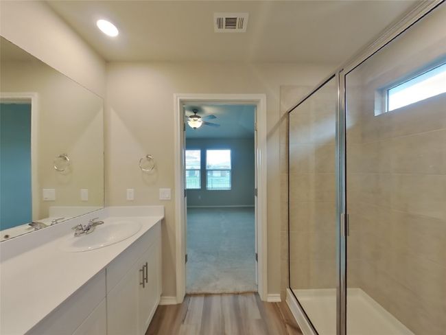 Full bathroom featuring vanity, a stall shower, wood finished floors, and a ceiling fan | Image 7