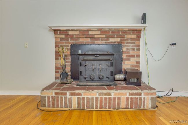 Interior details with a fireplace, wood-type flooring, and a wood stove | Image 10