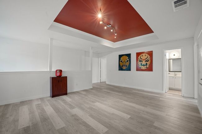 Unfurnished room with a tray ceiling and light wood-style flooring | Image 18