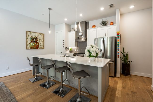 Modern kitchen with island includes SS refrigerator | Image 9