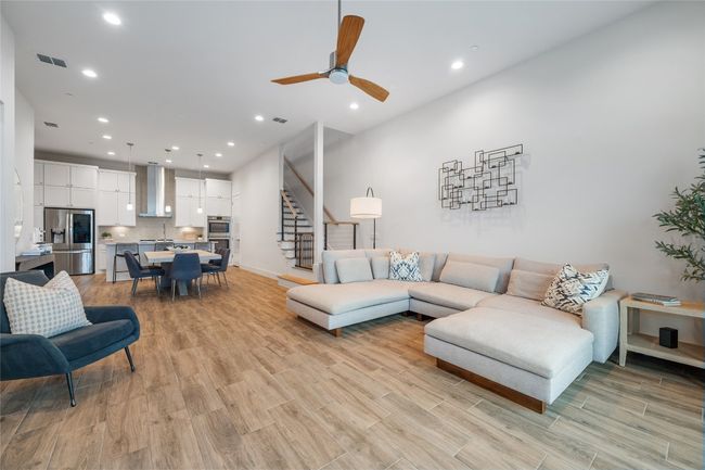 A bright and inviting open-concept main floor connecting living, dining, and kitchen areas. | Image 6