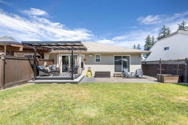 Rear view of house with a patio area, fence, a wooden deck, and a lawn | Image 29