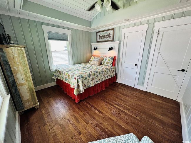 Bedroom featuring dark hardwood / wood-style flooring, vaulted ceiling, and ceiling fan | Image 19