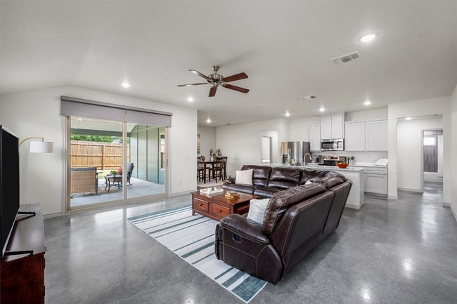Living area featuring a ceiling fan, visible vents, finished concrete floors, and recessed lighting | Image 4