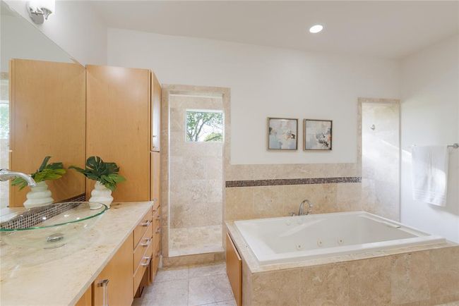 Full bathroom with vanity, a whirlpool tub, a tile shower, and tile patterned floors | Image 21
